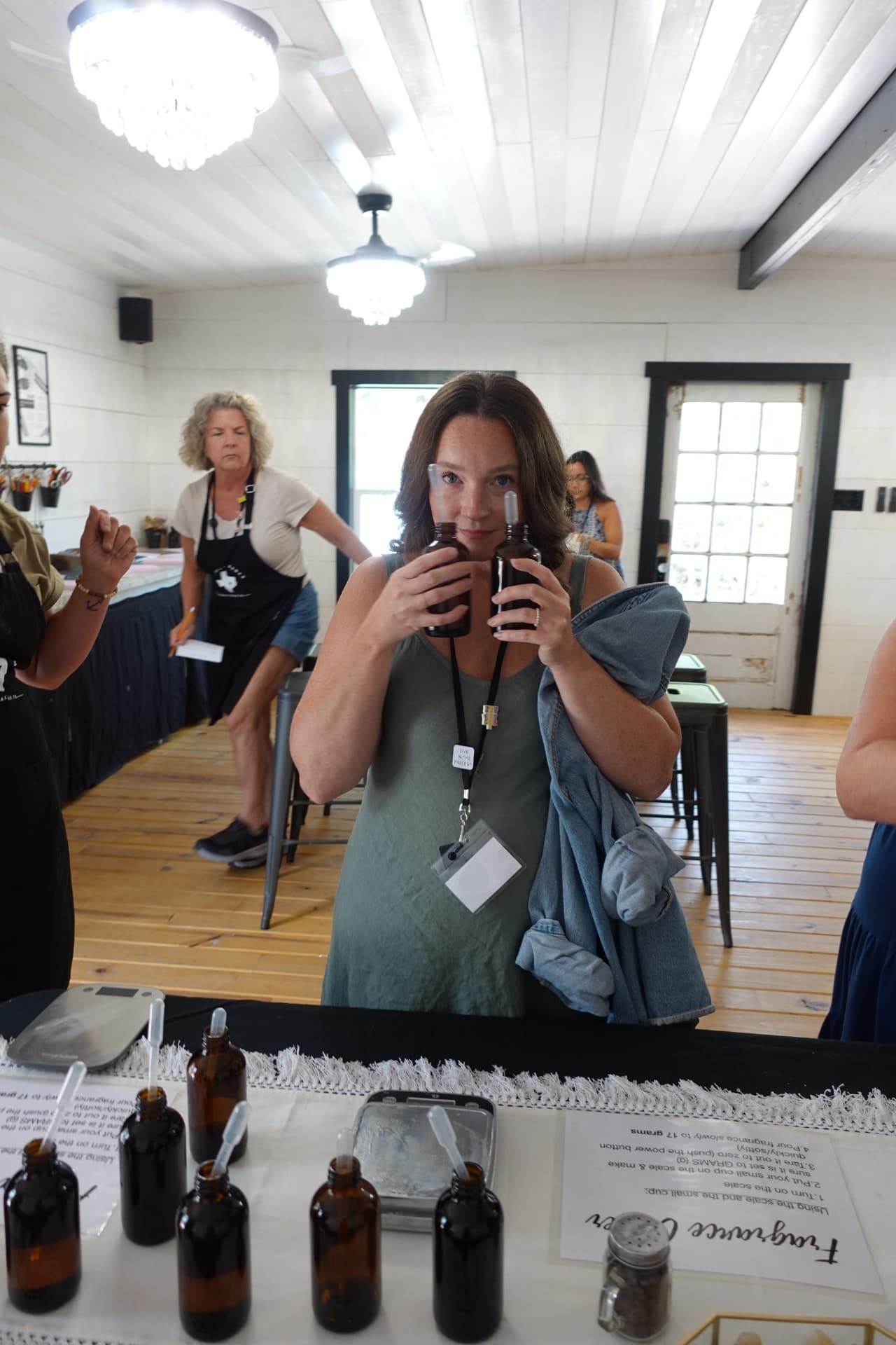 A guest comparing fragrance bottles during a candle-making workshop