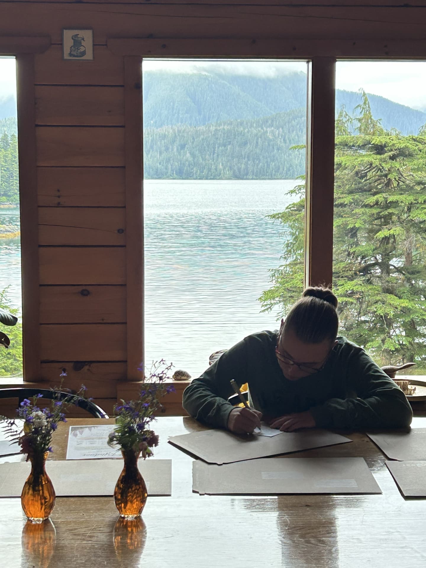 A Wild N Well guest writing beside the Sitka landscape