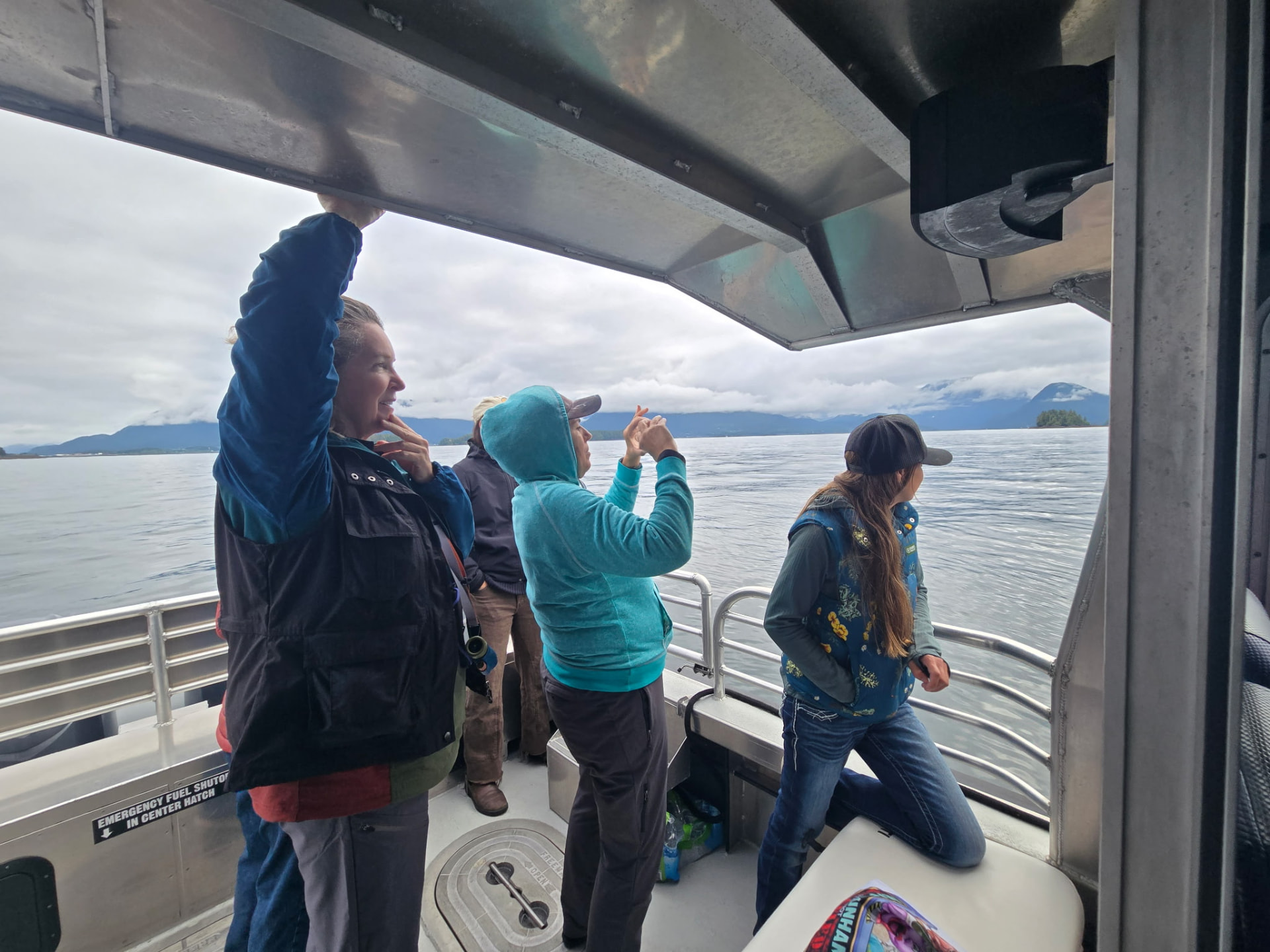 Guests watching the misty Sitka coastline from a small boat