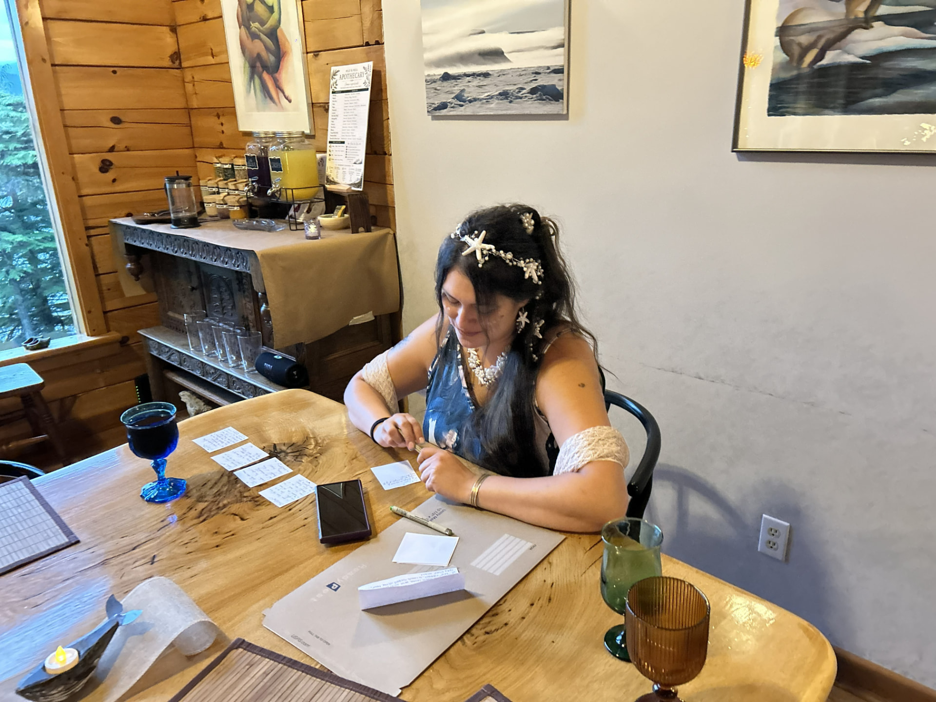 A Wild N Well guest writing reflection cards at the cabin table