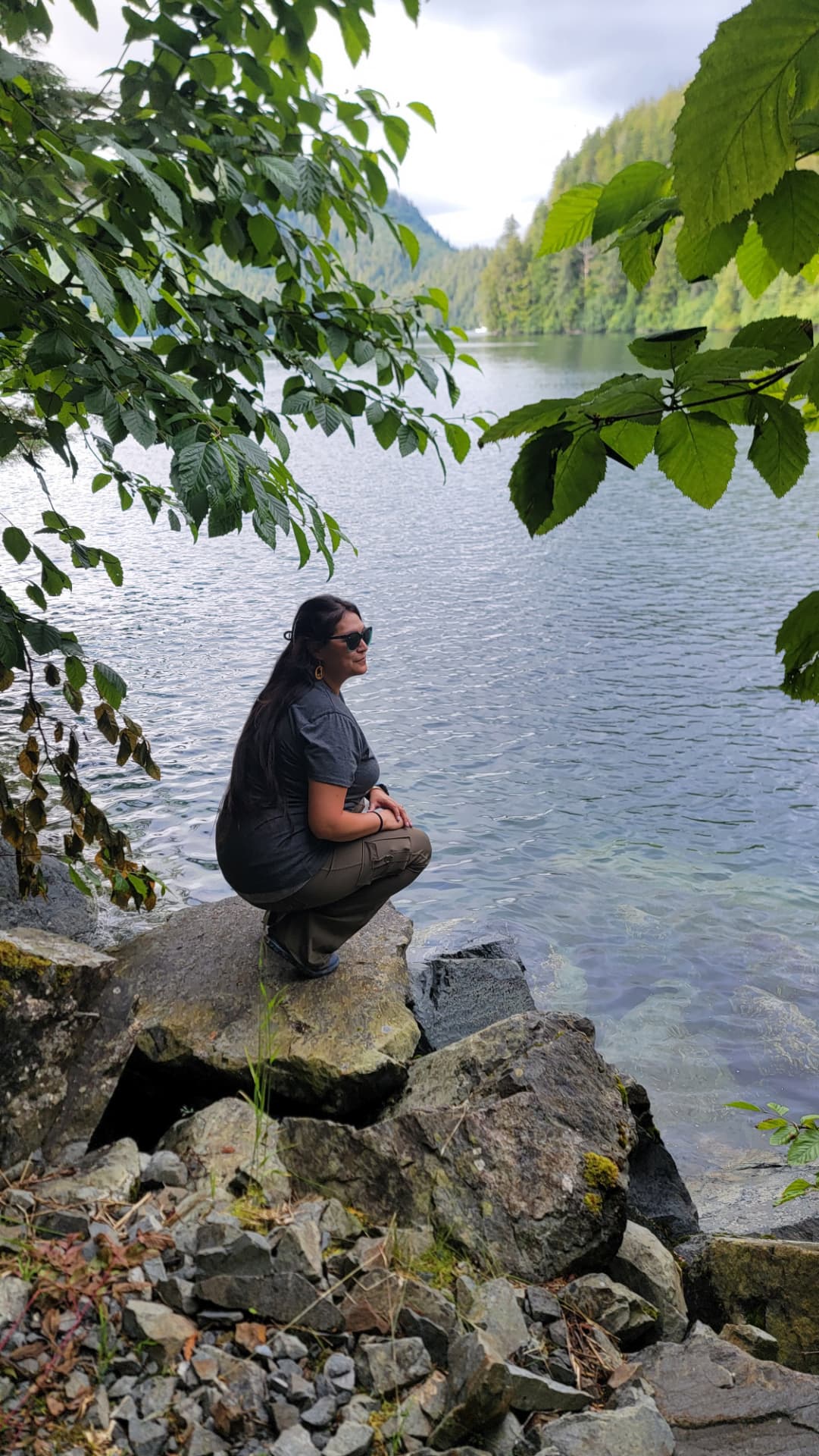 A Wild N Well guest taking in a quiet lake surrounded by Sitka forest