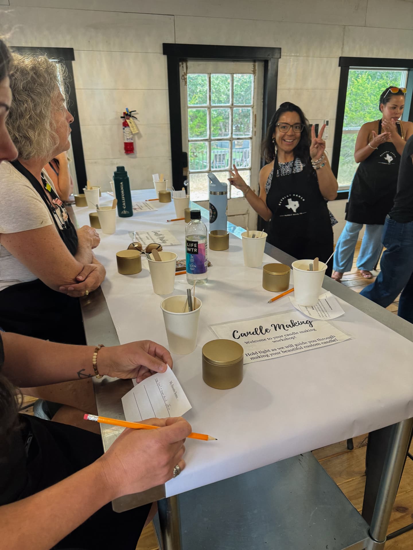 Women gathered around a prepared candle-making table during a creative session