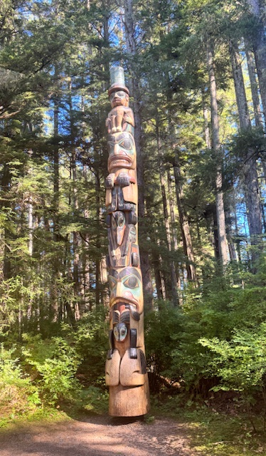 A carved totem among the trees in Sitka