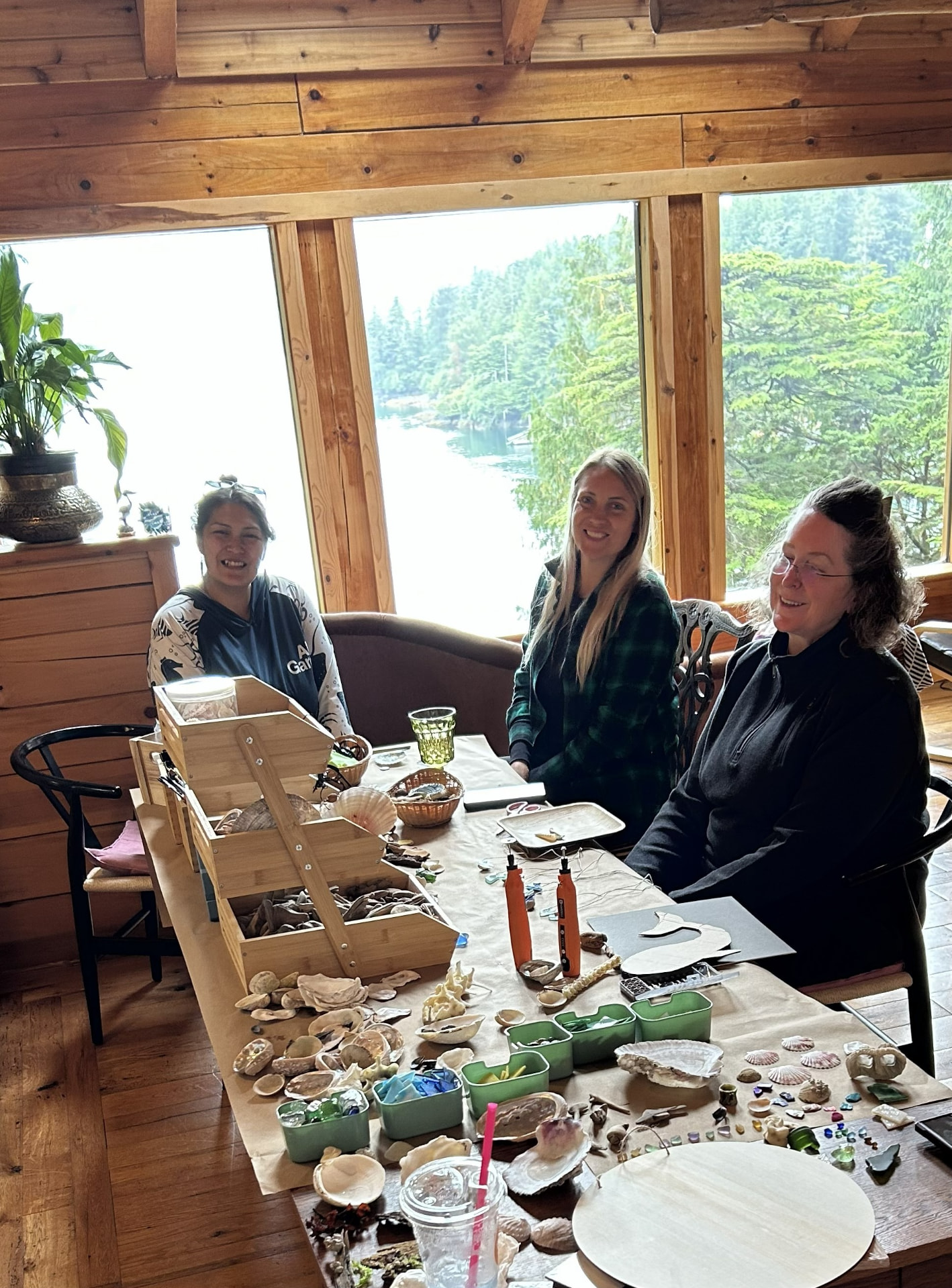 Three guests smiling around a table of creative materials