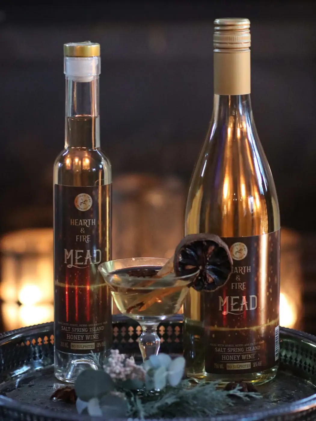 Original client photo of large and small Hearth and Fire bottles with a glass on a serving tray