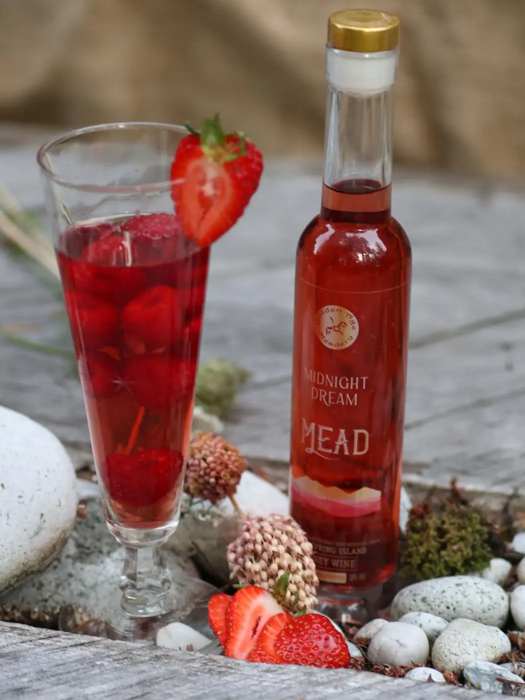 Small Midnight Dream bottle beside a berry drink and strawberries